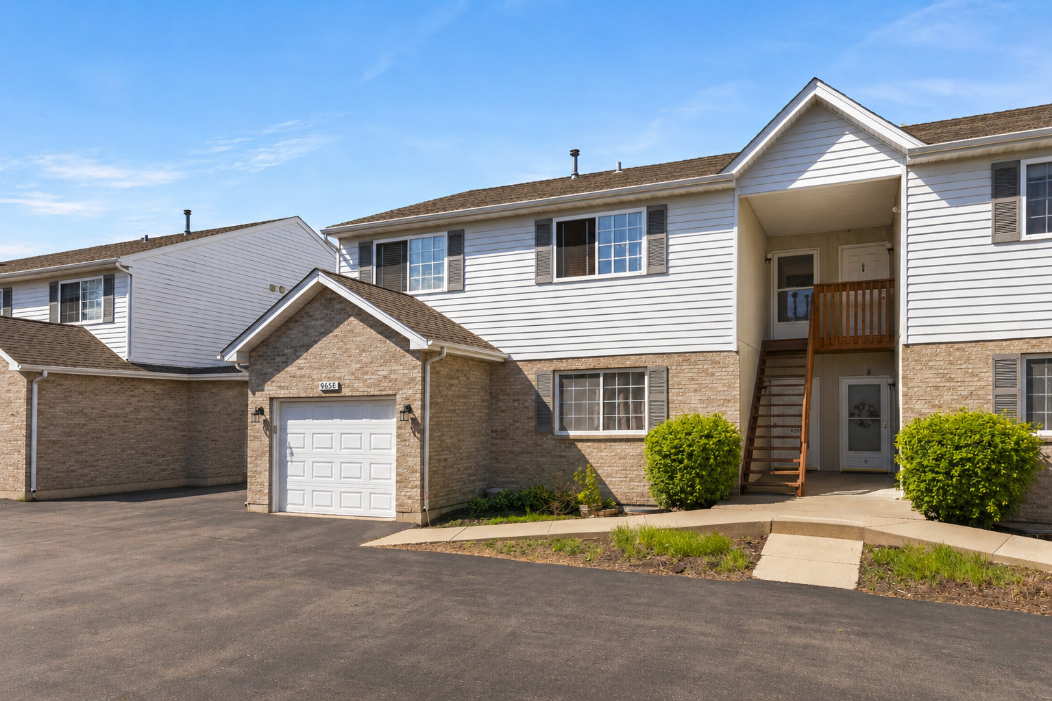 965 Constance Lane, Unit G Sycamore, IL 60178 - Photo 2 of 25 a front view of a house with a yard and garage