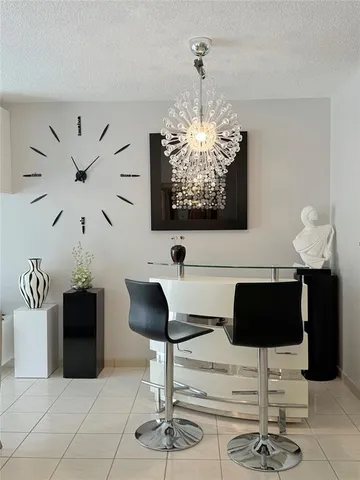a kitchen with a chandelier a refrigerator and cabinets