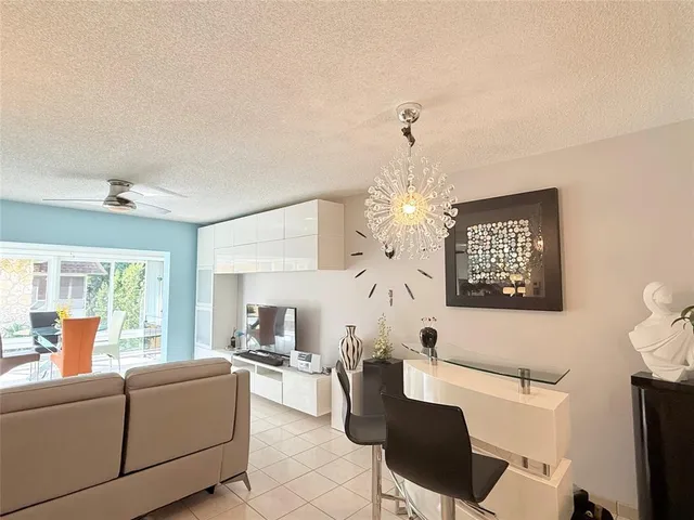 a living room with furniture a dining table and a chandelier