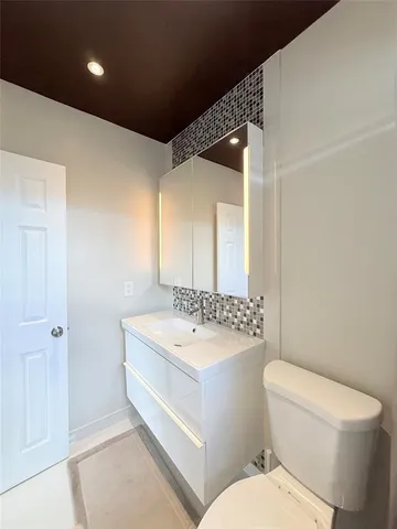 a bathroom with a sink a toilet a mirror and shower