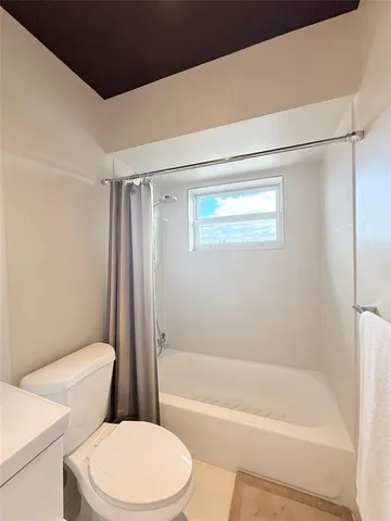a white toilet and tub sitting next to a bathroom sink