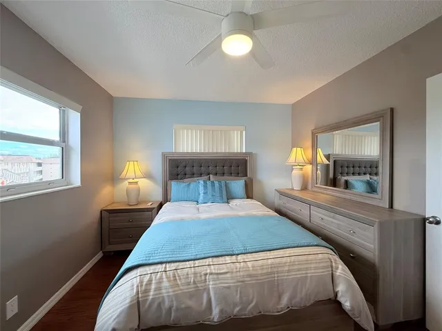 a bedroom with a bed and window with wooden floor