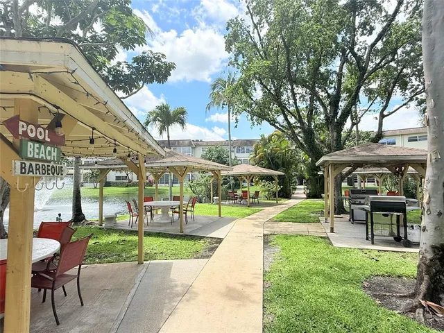 a view of a swimming pool with a table and chairs under an umbrella