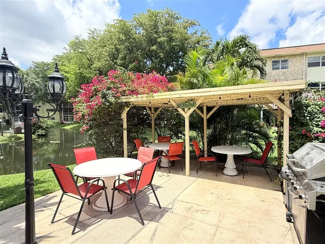 a view of a patio with table and chairs potted plants with wooden floor and fence