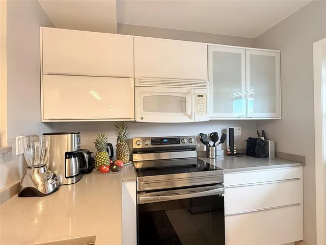 a kitchen with a sink and a stove next to a white cabinet