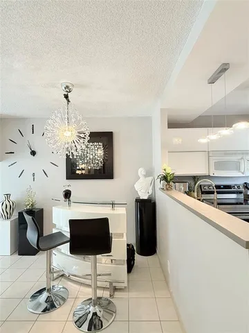 a kitchen with stainless steel appliances kitchen island granite countertop a table and a chair