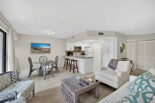 a living room with furniture a rug and white walls