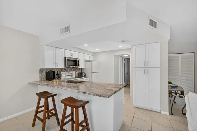 a kitchen with white cabinets and white appliances