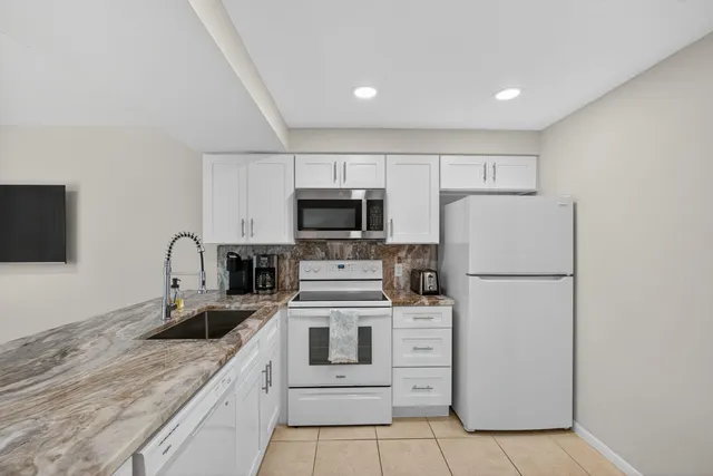 a kitchen with sink a microwave and cabinets