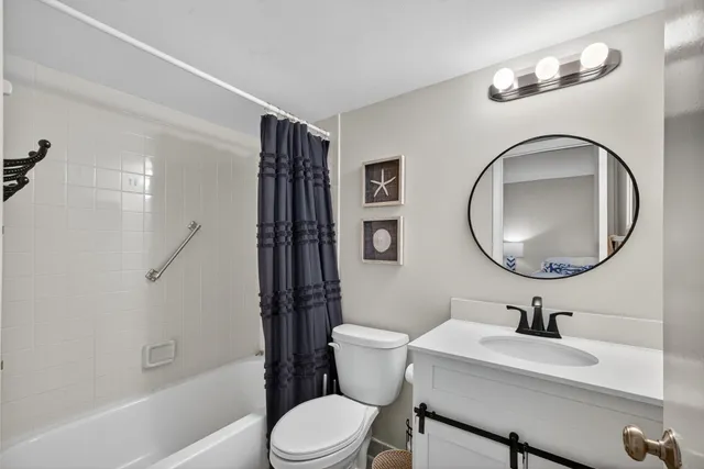 a bathroom with a granite countertop toilet sink and mirror
