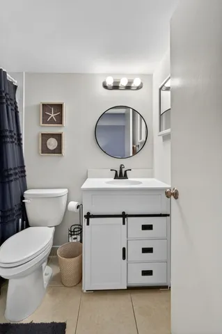 a bathroom with a toilet a sink and mirror