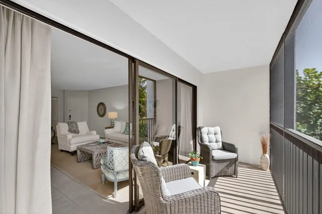 a balcony with wooden floor table and chairs