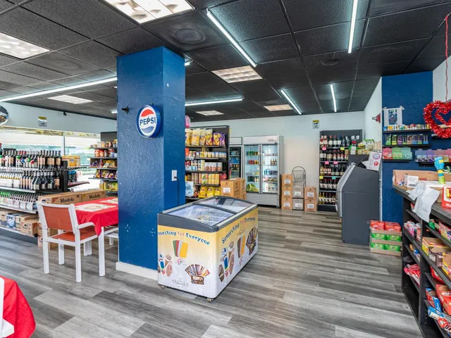 a storage room with stainless steel appliances wooden floor and table