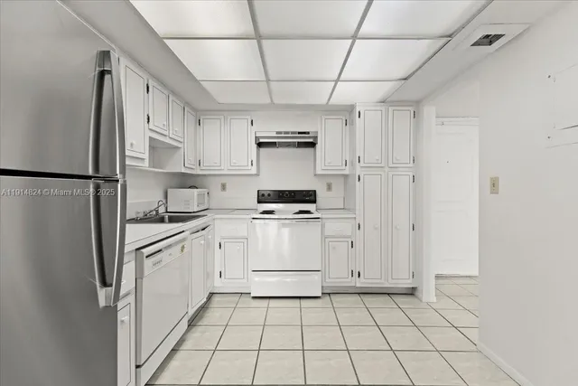 a kitchen with stainless steel appliances a refrigerator sink and cabinets