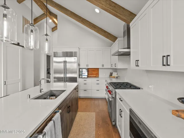 a kitchen with a sink a counter top space and stainless steel appliances