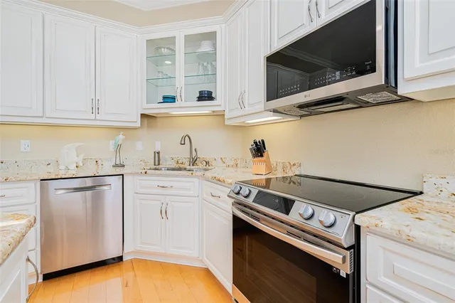 a kitchen with stainless steel appliances granite countertop a sink dishwasher stove and cabinets