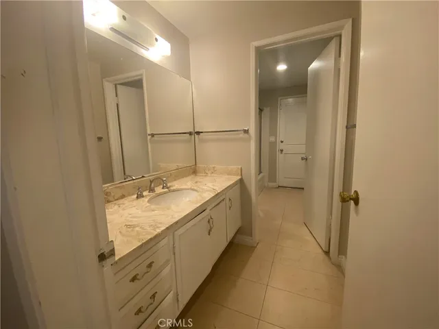 a bathroom with a granite countertop sink mirror and a bathtub