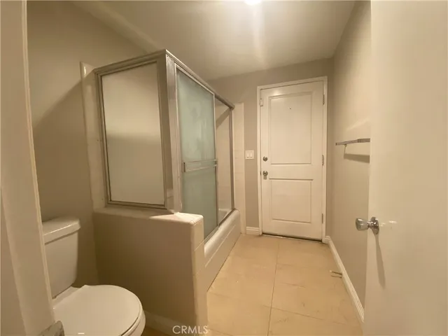 a bathroom with a granite countertop toilet a sink and mirror