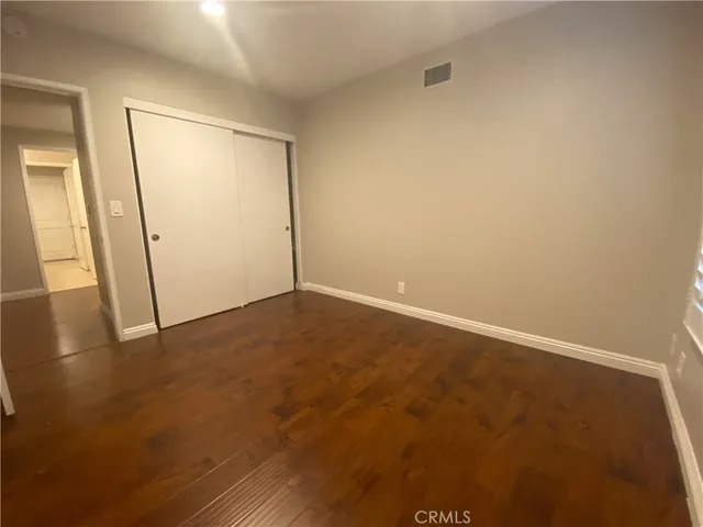 an empty room with wooden floor and door