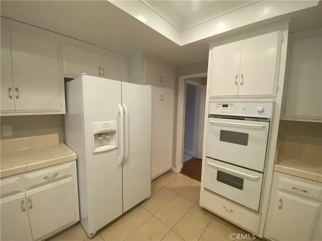 a white refrigerator freezer and a stove sitting inside of a kitchen