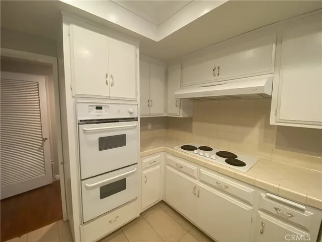 a kitchen with white cabinets and white appliances