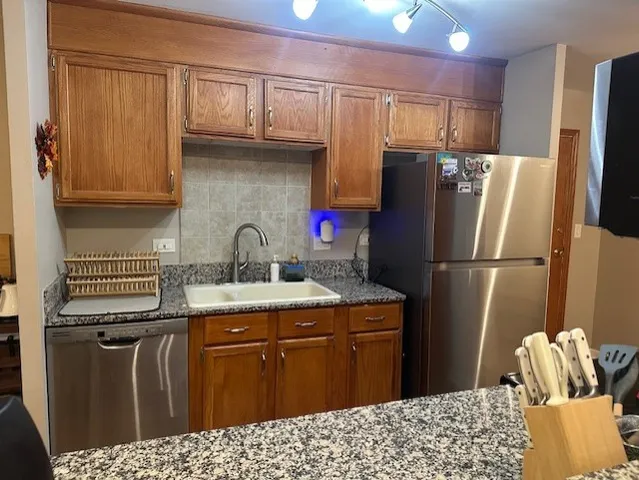 a kitchen with stainless steel appliances granite countertop a refrigerator sink and cabinets