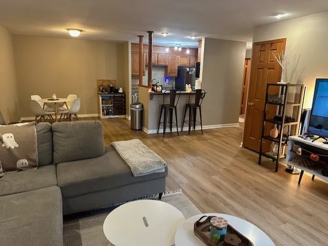 a living room with furniture a dining table and wooden floor