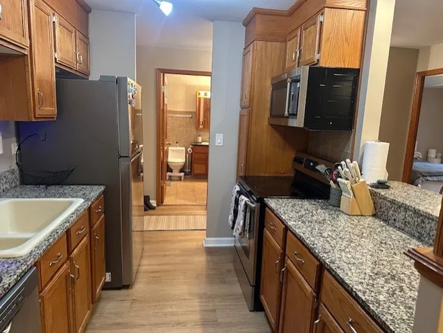 a kitchen with stainless steel appliances granite countertop a sink stove and refrigerator