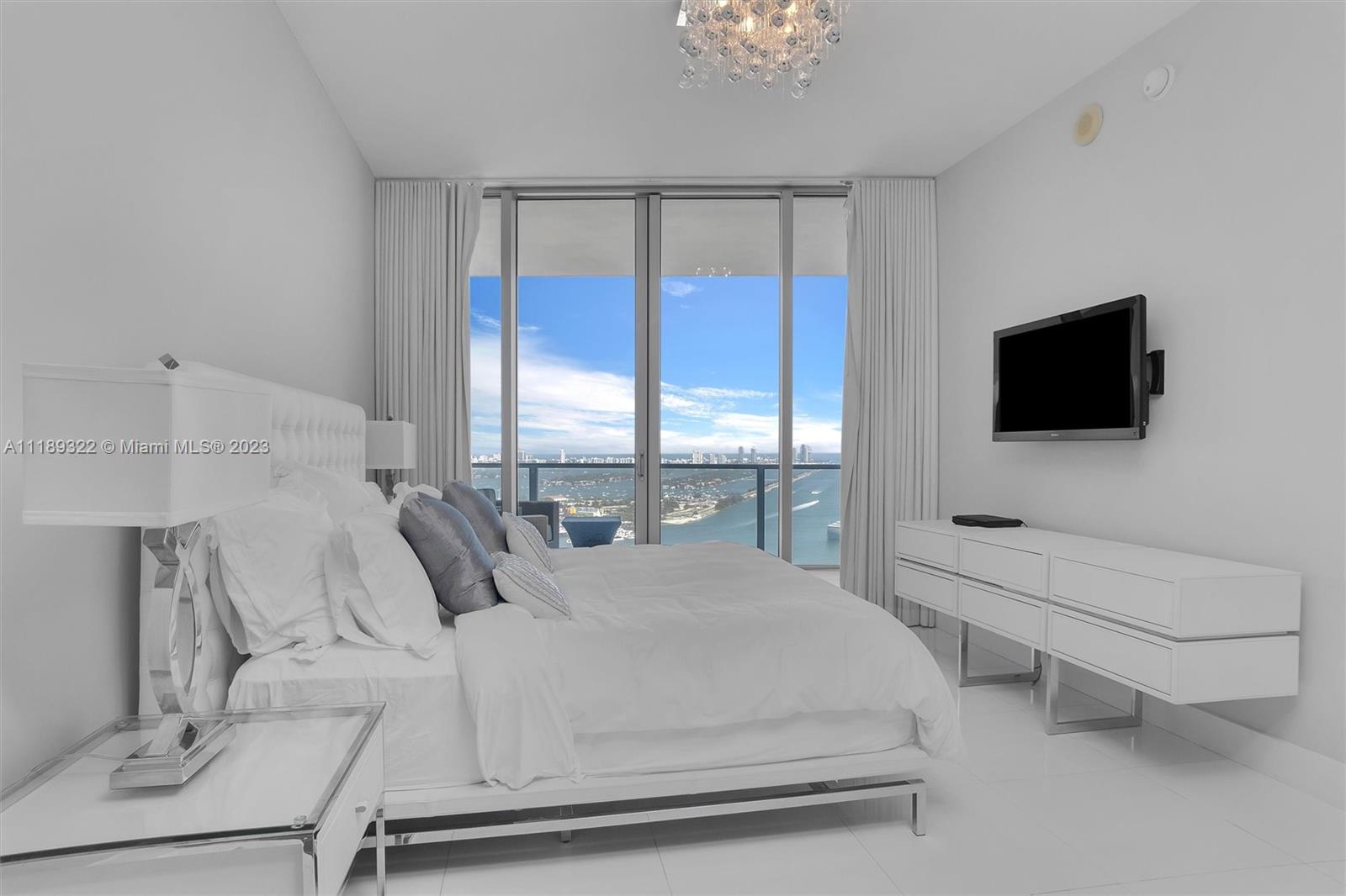1100 Biscayne Boulevard, Unit 4204 Miami, FL 33132 - Photo 11 of 30 a bedroom with a bed and a flat tv screen on the dresser