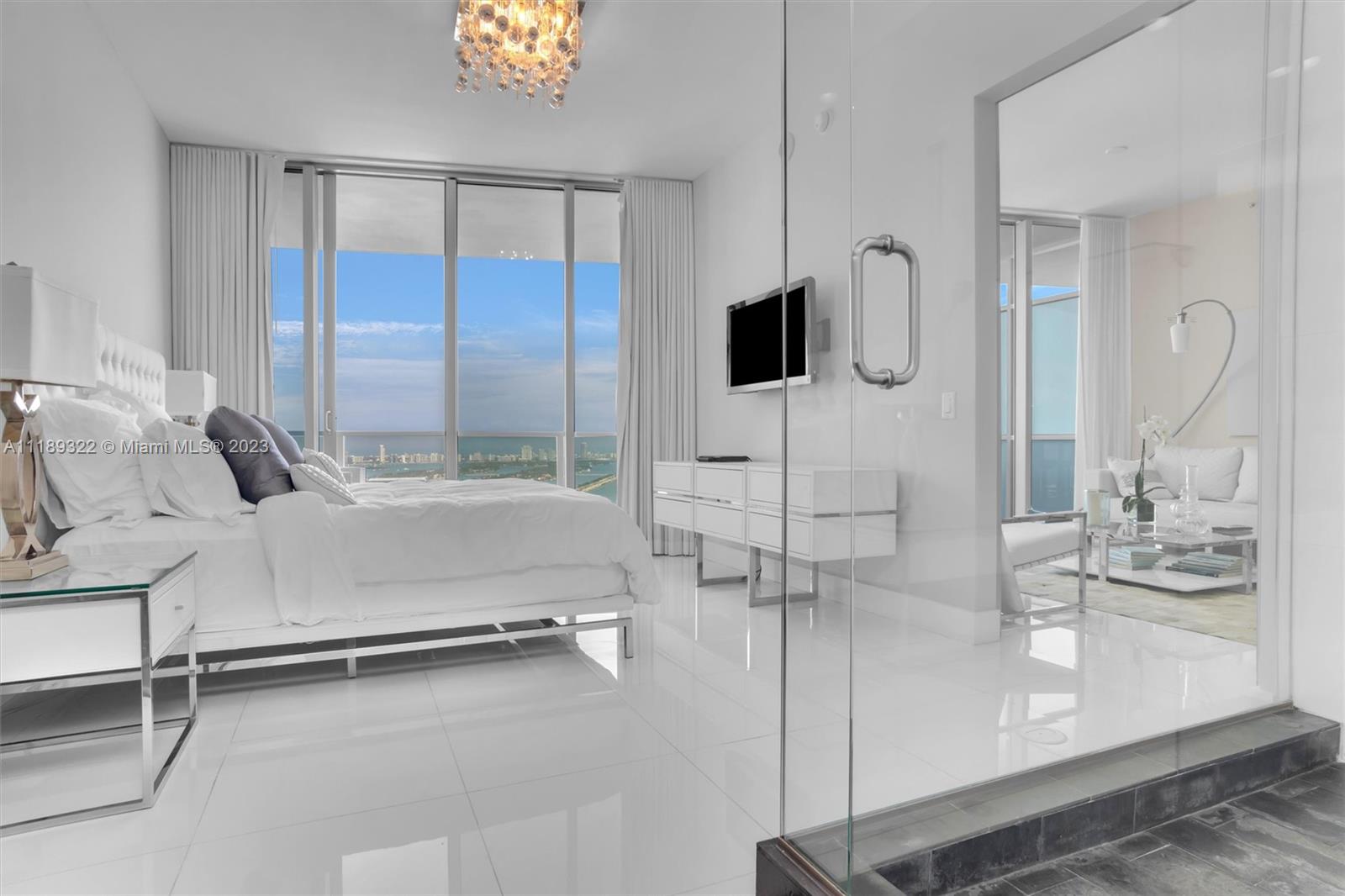1100 Biscayne Boulevard, Unit 4204 Miami, FL 33132 - Photo 13 of 30 a bedroom with a bed a flat screen tv and balcony view