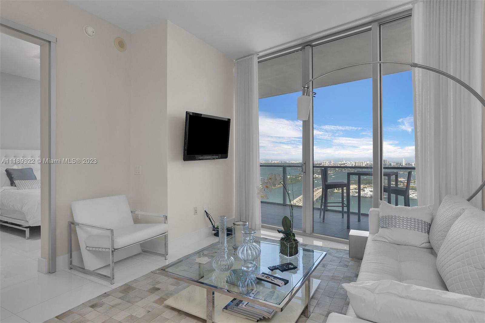 1100 Biscayne Boulevard, Unit 4204 Miami, FL 33132 - Photo 8 of 30 a living room with furniture a flat screen tv and a large window