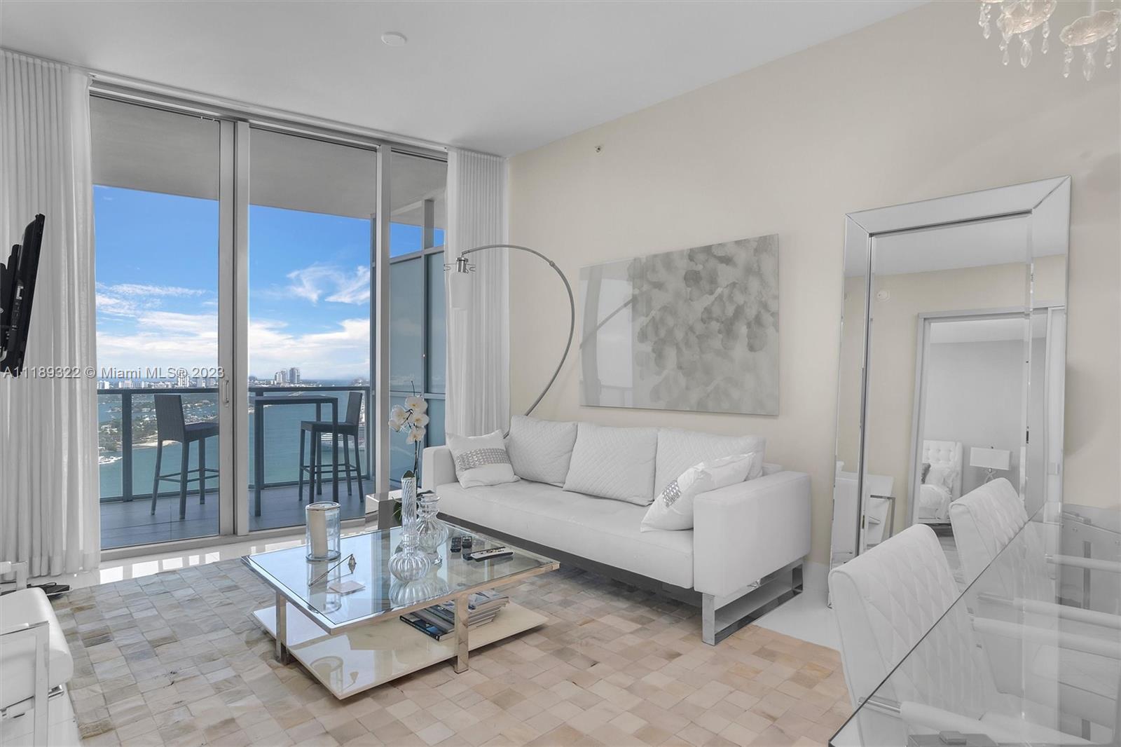 1100 Biscayne Boulevard, Unit 4204 Miami, FL 33132 - Photo 9 of 30 a living room with furniture a glass table and a chandelier