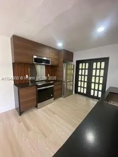 a large kitchen with stainless steel appliances a large counter top