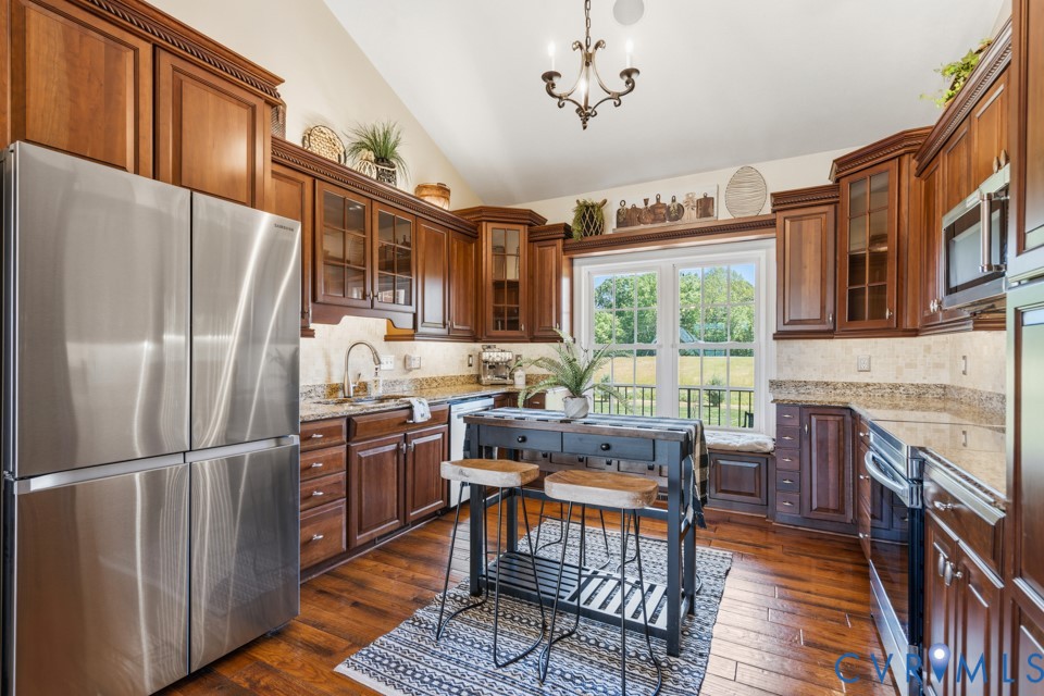 7191 Figuly Road Mechanicsville, VA 23111 - Photo 11 of 46 a kitchen with stainless steel appliances granite countertop a refrigerator a stove top oven a sink dishwasher and wooden cabinets