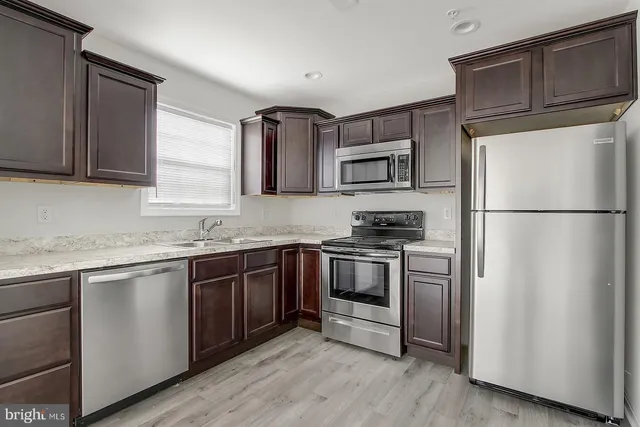 a kitchen with stainless steel appliances granite countertop a refrigerator stove and sink