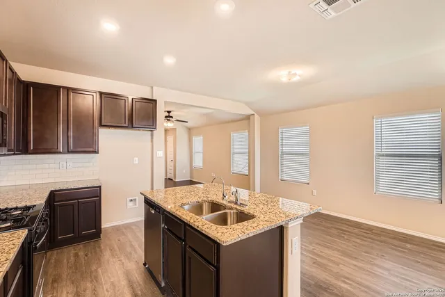 a kitchen with granite countertop a sink stove and cabinets