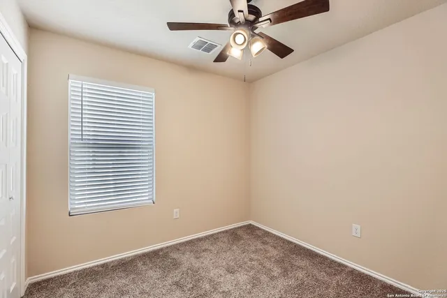 an empty room with a window and a fan