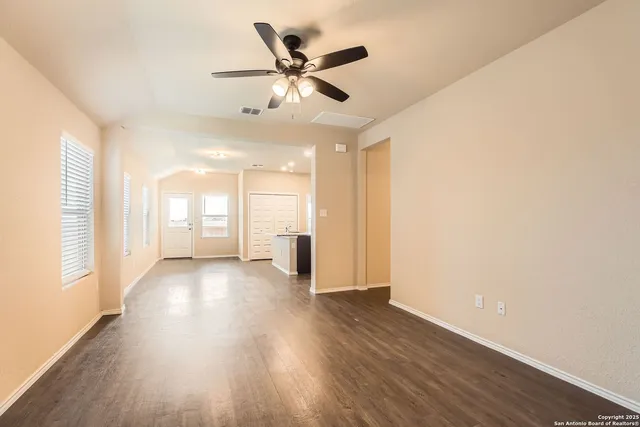 a view of a livingroom with a ceiling fan and wooden floor