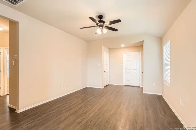 a view of an empty room with wooden floor