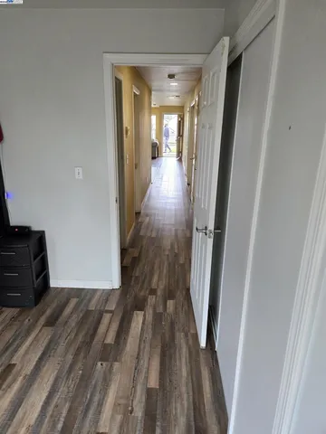 a view of a hallway with wooden floor and staircase