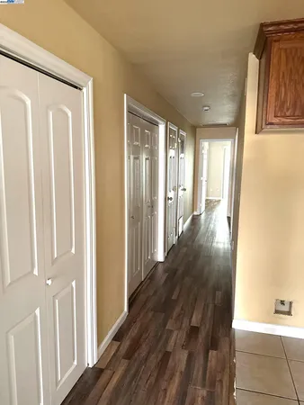 a view of a hallway with wooden floor and staircase