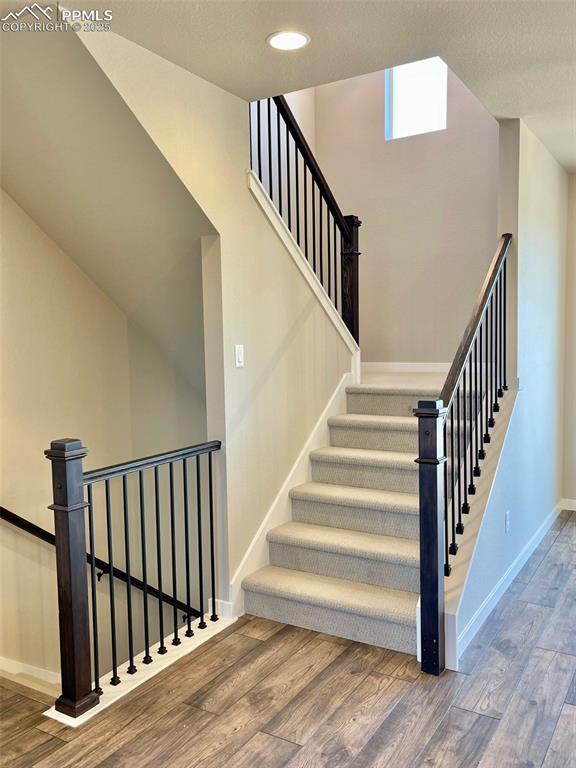 3527 Summer Dream Avenue Colorado Springs, CO 80922 - Photo 18 of 26 a view of staircase with lots of frames on wall and wooden floor