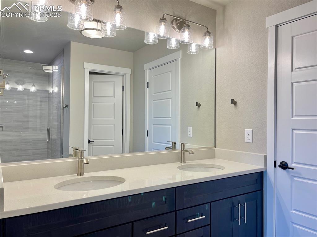 3527 Summer Dream Avenue Colorado Springs, CO 80922 - Photo 22 of 26 a bathroom with double vanity sinks and a mirror