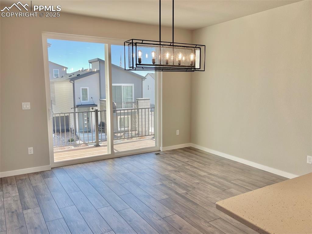 3527 Summer Dream Avenue Colorado Springs, CO 80922 - Photo 8 of 26 a view of empty room with wooden floor
