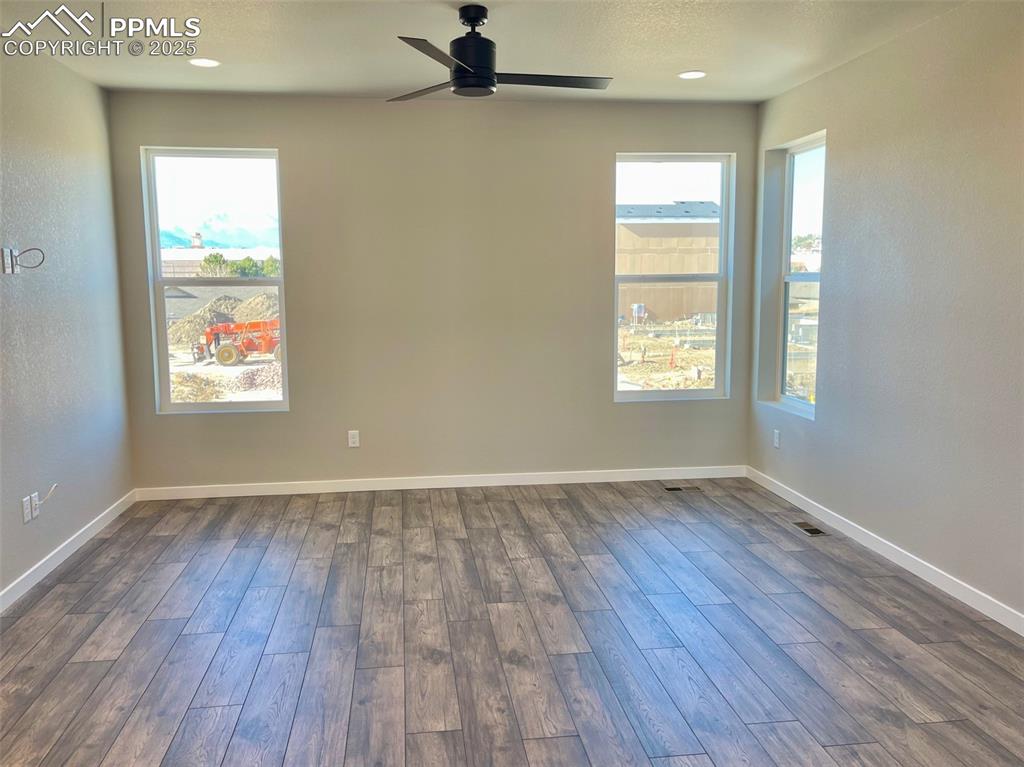 3527 Summer Dream Avenue Colorado Springs, CO 80922 - Photo 10 of 26 an empty room with wooden floor and windows