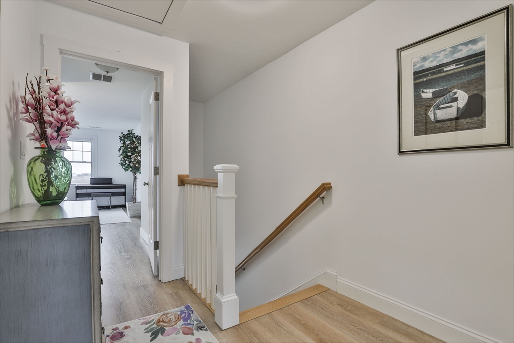 207 Beach Road, Unit C2 Salisbury, MA 01952 - Photo 23 of 35 a view of a hallway with wooden floor and a potted plant
