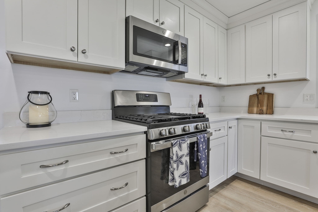 207 Beach Road, Unit C2 Salisbury, MA 01952 - Photo 6 of 35 a kitchen with white cabinets and appliances