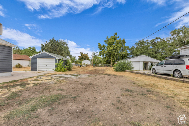 View of yard with a garage and an outdoor structure