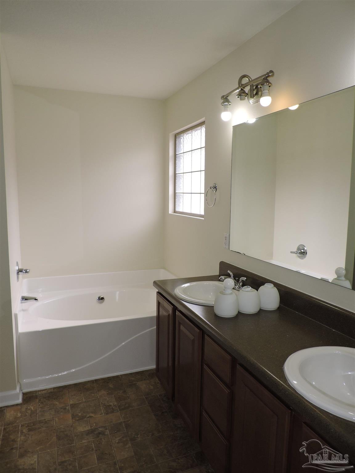 7070 Marissa Point Lane Milton, FL 32570 - Photo 11 of 21 a bathroom with a sink vanity and a mirror