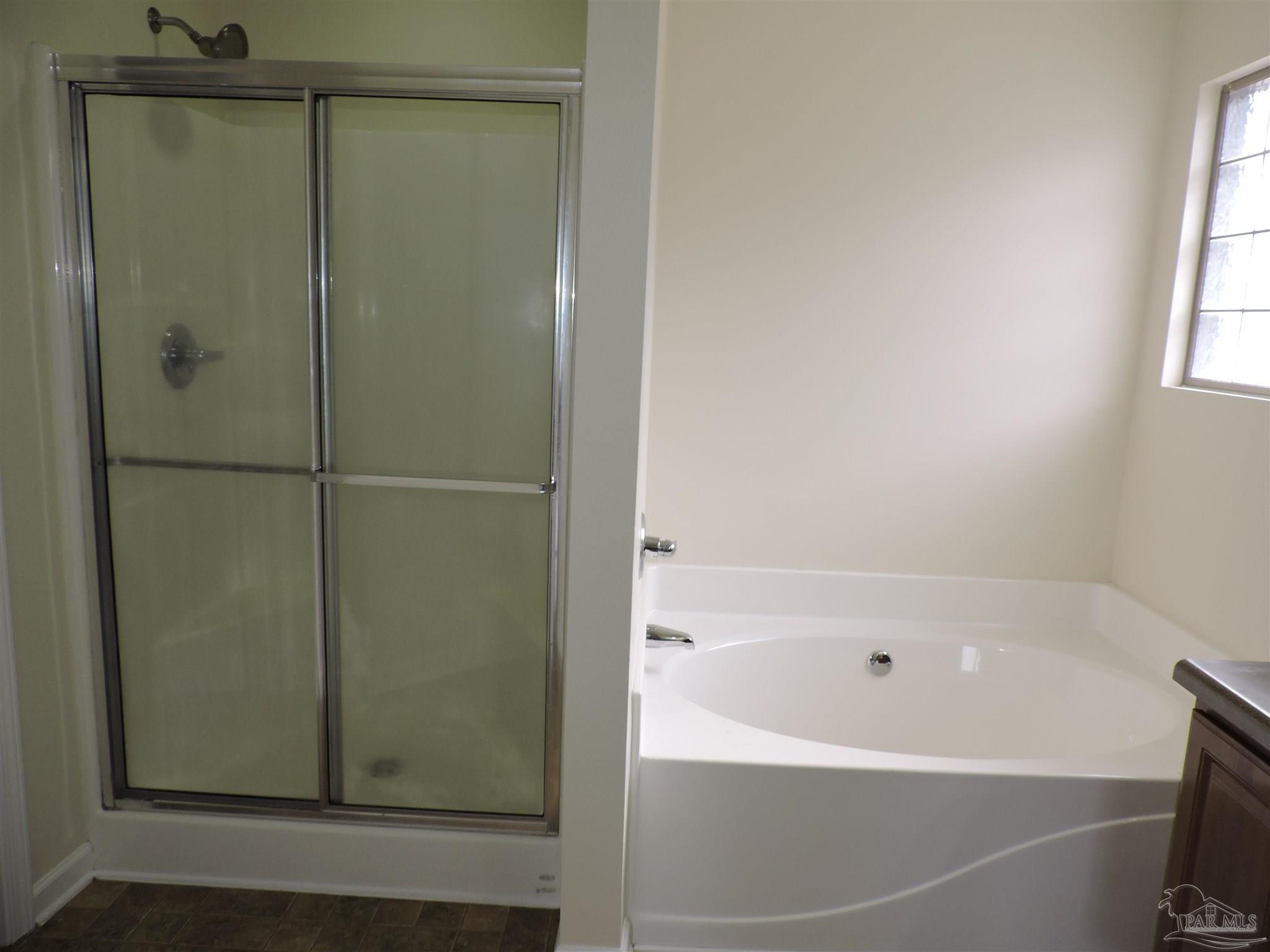 7070 Marissa Point Lane Milton, FL 32570 - Photo 12 of 21 a bathroom with a bathtub and a shower